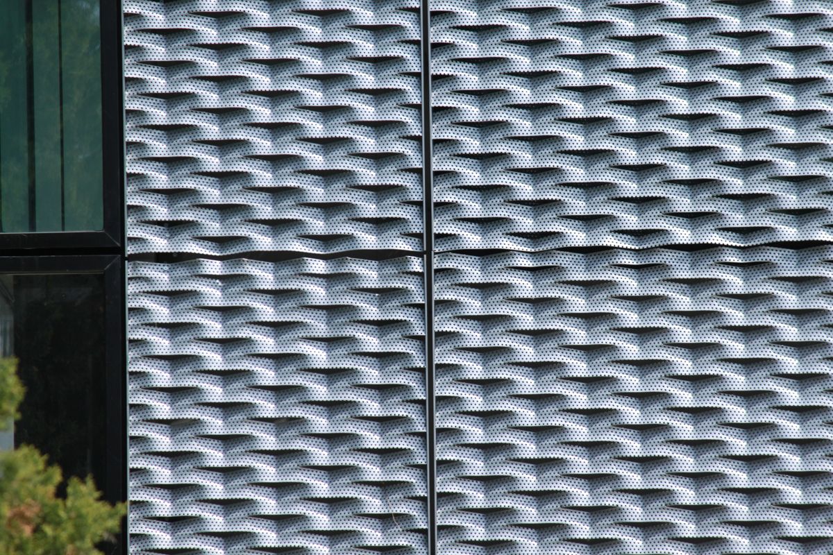 Parement de façade par panneaux de métal perforé déployé